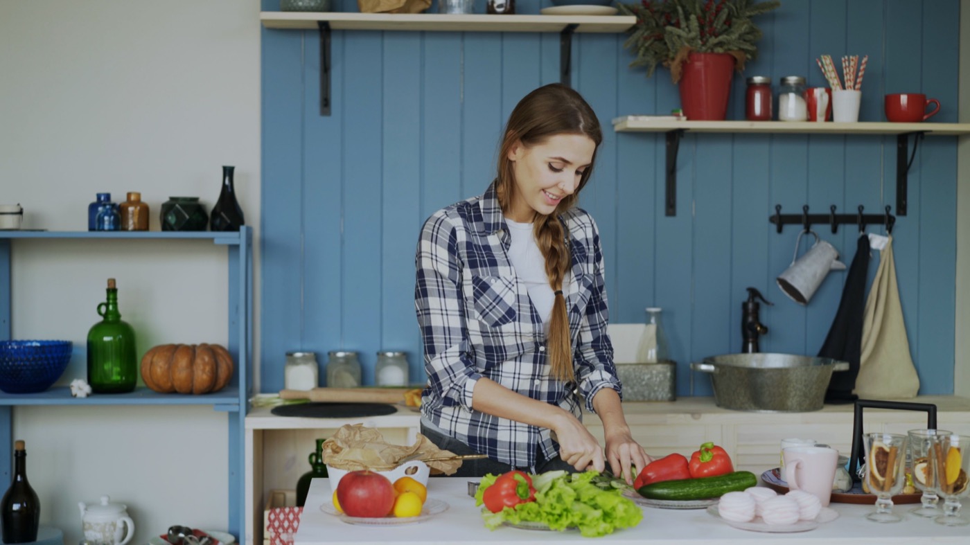 Jeune femme cuisinant dans une cuisine colorée