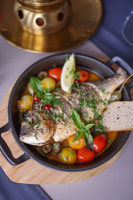 Plat de poisson rôti avec légumes et herbes fraîches